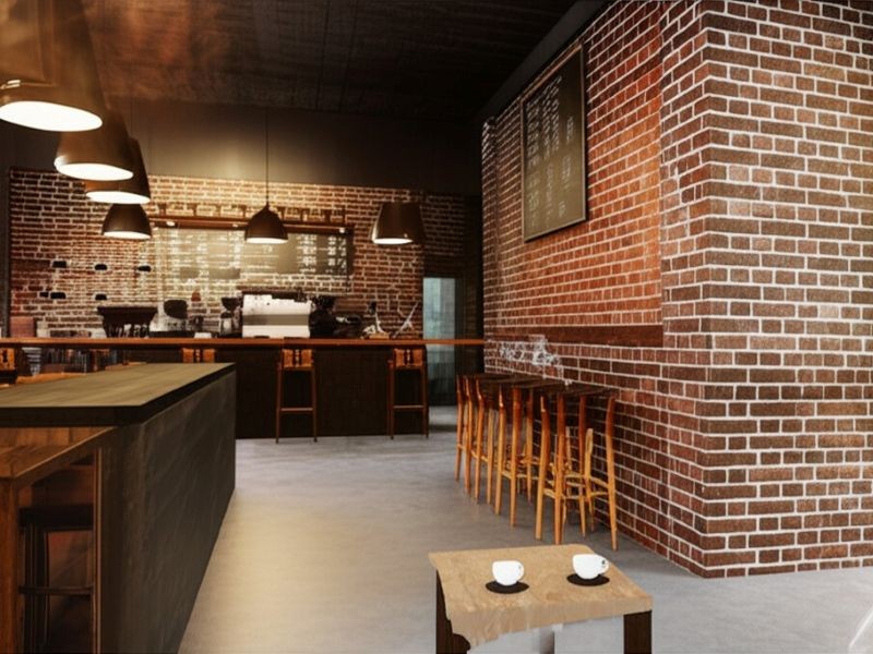 A coffee shop with brick walls and a small table in the front. 