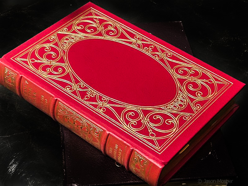 A red leather book on a dark surface.