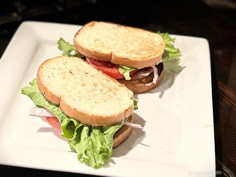 Two BLT sandwiches on a cooking sheet. 
